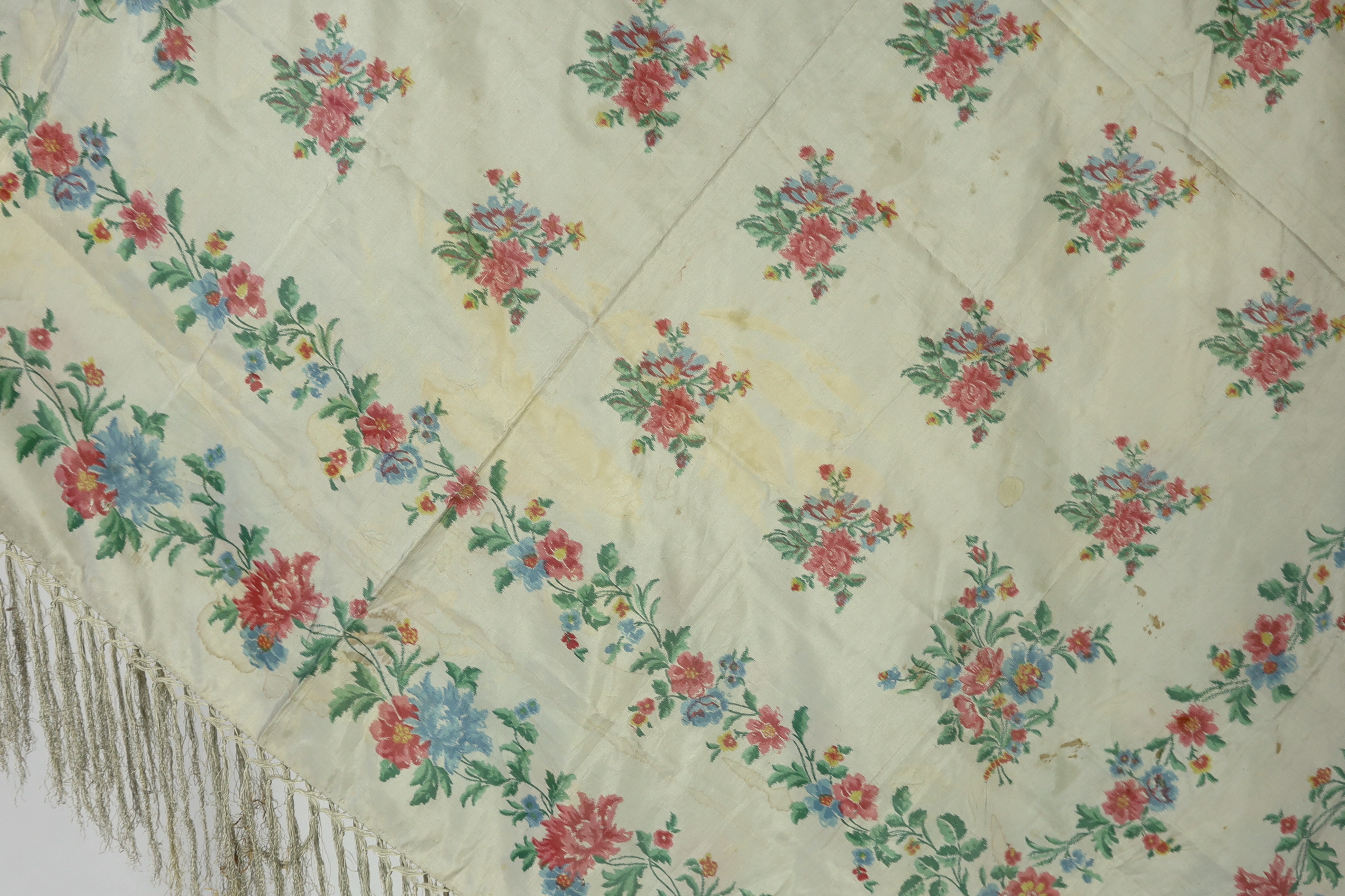 A French silk shawl, c.1800-1840, of a type modelled by Madame Recamier in the painting by François Gerard, printed on the warp thread into a rose pattern, with long fringing, 174 x 170cm